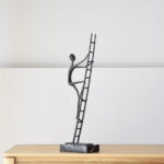 ESCULTURA ESCALANDO METAL Y MÁRMOL